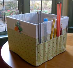 an organized storage bin on a table in front of a window