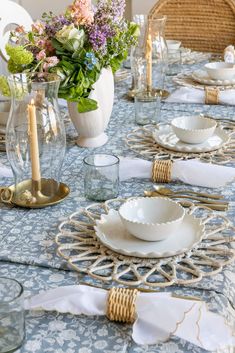 the table is set with white dishes and place settings