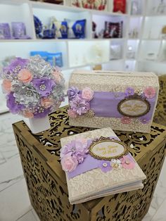 two purses with flowers on them are sitting on a table in front of a vase