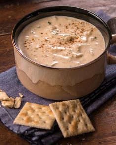 a bowl of soup with crackers on the side