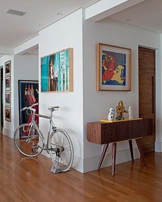 there is a bike that is parked in the hallway next to some pictures on the wall