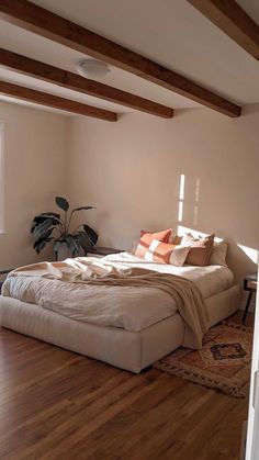 a bed sitting on top of a wooden floor next to a window