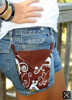 a woman's jeans shorts with a brown and white purse on the back pocket