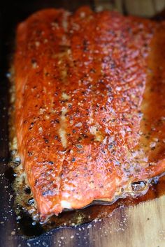 a piece of cooked salmon on a wooden cutting board