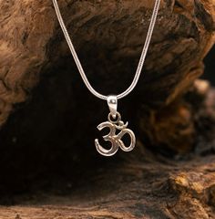 This small silver pendant shows the Om Sanskrit symbol. The divine symbol OM literally means: "I am." The OM is made up of A, U and M, which stand for the three divine aspects: Vishnu (A), Shiva (U) and Brahma (M). The vibration of the OM is considered to be the universal and eternal vibration that represents the junction between the absolute and the relative world. Everything is said to have originated from it. It has no beginning and no end. OM is not only a beautiful symbol. OM is also the sound that people have used for thousands of years to create harmony between the body, mind and soul. This is possible because ultimately all vibrations in the universe can be traced back to the primordial sound OM. The nickel-free pendant is made of 925 sterling silver and measures approx. 10 mm with Spiritual Sterling Silver Charm Necklace With Round Pendant, Spiritual Sterling Silver Nickel Free Charm Necklace, Spiritual Sterling Silver Nickel-free Charm Necklace, Silver Symbolic Pendant Charm Necklace, Silver Symbolic Charm Necklace With Round Pendant, Silver Symbolic Pendant Charm Necklaces, Spiritual Silver Jewelry With Initial Pendant, Silver Initial Pendant Jewelry, Spiritual Style, Spiritual White Gold Pendant Charm Necklaces