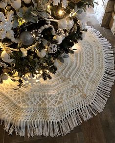 a white christmas tree skirt with lights on it