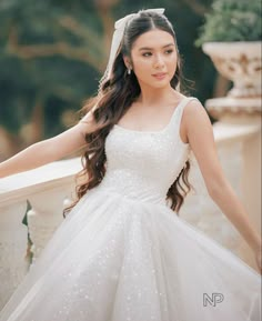 a beautiful young woman in a wedding dress posing for the camera with her hand on her hip