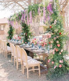 an outdoor dining area with flowers and greenery