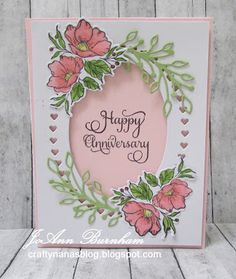 a happy anniversary card with pink flowers and green leaves on the front, surrounded by hearts