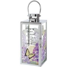 a glass lantern with a butterfly on the front and purple flowers in the back that says, i love you