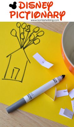 a cup and some scissors on a yellow paper with the words disney pictionary next to it