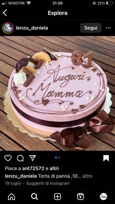 a pink cake sitting on top of a wooden table next to a brown and white ribbon