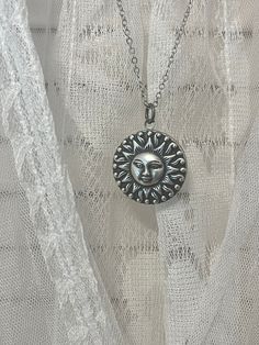 "Silver locket with a beautiful and detailed sun face charm.  This locket is 1\" round and can hold two 3/4\" photos. I love the size of these lockets.  Also, the metal is stainless steel, so it is perfect for anyone with skin allergies!  A great metal that will not tarnish with time.  Love them! The sun charm has great detail and it completely covers the locket, making it a secret compartment necklace!  This is a brass sun with a sterling silver plating. Chain is nice quality and closes off wit Bohemian Engraved Round Locket Necklace, Bohemian Jewelry With Sun Design Round Pendant, Bohemian Round Necklace With Sun Design, Bohemian Sun Design Round Pendant Jewelry, Adjustable Vintage Jewelry With Sun Design, Silver Medallion Necklace With Sun Design, Sun And Moon Design Jewelry For Festivals, Symbolic Round Sun Design Necklace, Symbolic Sun Design Round Necklace