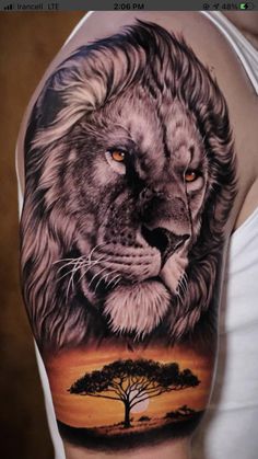 a man's arm with a lion and tree tattoo on the left side of his arm