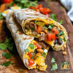 a burrito cut in half on a cutting board topped with vegetables and meats