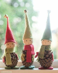 three little gnomes sitting next to each other on top of a window sill