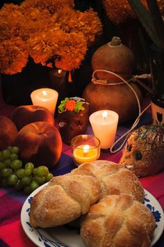 a table topped with bread and candles next to pumpkins