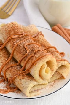 a plate topped with crepes covered in cinnamon