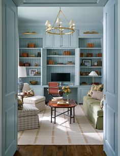 a living room filled with furniture and bookshelves next to a doorway that leads to a sitting area