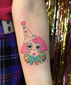 a woman with a tattoo on her arm wearing a clown hat and bow tie around her neck