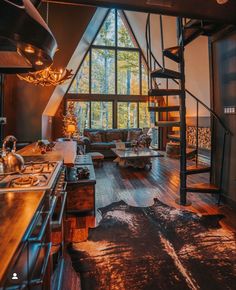 a living room filled with lots of furniture and a staircase leading up to the top floor