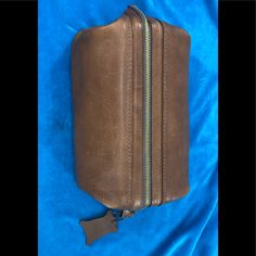 a brown leather case with two zippers on it