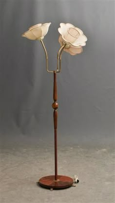 a wooden stand with two white flowers on it and a wire attached to the base