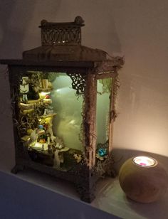 an old fashioned lantern is sitting on a shelf next to a candle