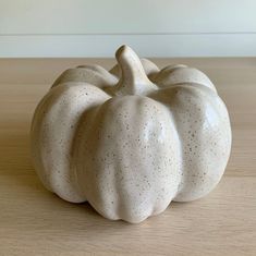 a white ceramic pumpkin sitting on top of a wooden table