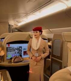 an air hostess standing in front of the computer screen