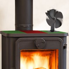 a stove with an open fire in it's center and a fan on top