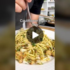 a person is eating spaghetti on a white plate