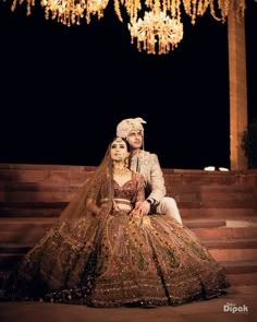 the bride and groom are sitting on some steps