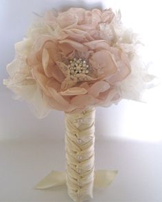 a bridal bouquet with pearls and lace on the top is sitting in front of a white background