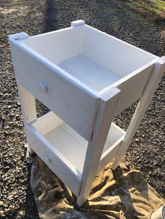 a white cabinet sitting on top of a pile of dirt