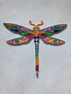 a multicolored dragonfly is hanging on the wall