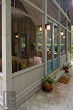 a porch with potted plants sitting on the side of it