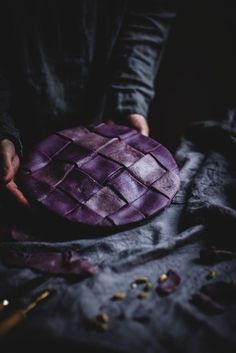 a person holding a purple object on top of a table