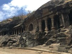 an ancient building built into the side of a rocky cliff with columns and pillars in it