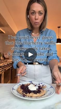 a woman standing in front of a plate of food with the words i bet you'd never guess that this blueberry waffle situation only takes 5 minutes to make and has 50 % off