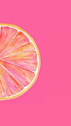 a grapefruit cut in half on a pink background