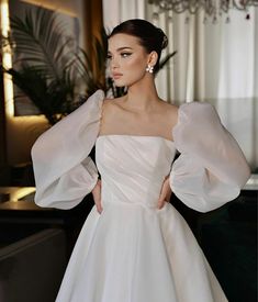 a woman in a white dress posing for the camera