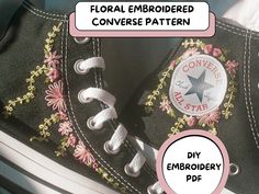 a pair of black converse shoes with flowers on the side and an embroiderer