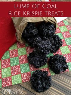 a pile of black rice krispy treats sitting on top of a green and red table cloth