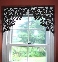 the window is decorated with black leaves and has a white valance on it's side