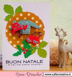 a close up of a card on a table near a figurine and a deer