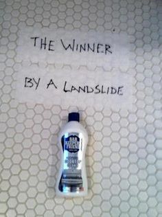 a bottle of hand sanitizer sitting on top of a white tiled floor next to a sign that says, the winner by a landslide