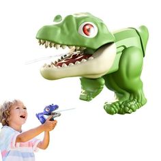 a little boy playing with a toy dinosaur flying in the air next to a fake t - rex