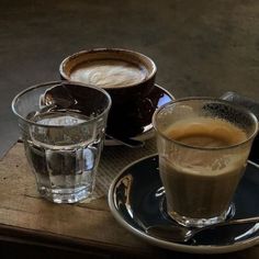 two cups of coffee sit next to each other on a table