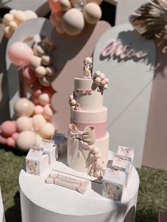 a three tiered wedding cake sitting on top of a table next to other decorations